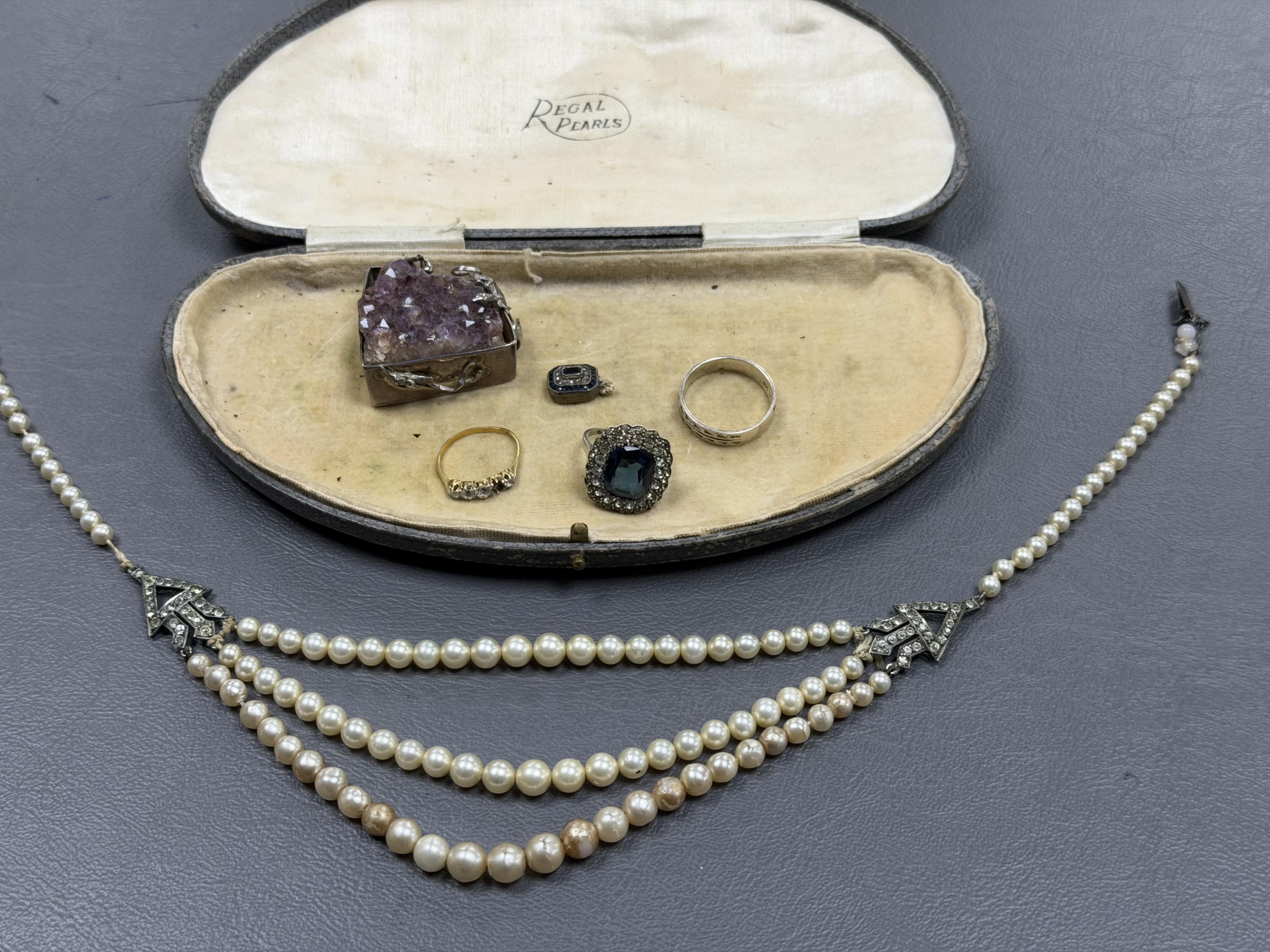 A collection of costume jewels, comprising: an Art Deco simulant pearl and paste necklace, clasp detached, case stamped Regal Pearls; a blue and colourless paste ring; a simulant diamond ring mounted in gold, size K1/2,